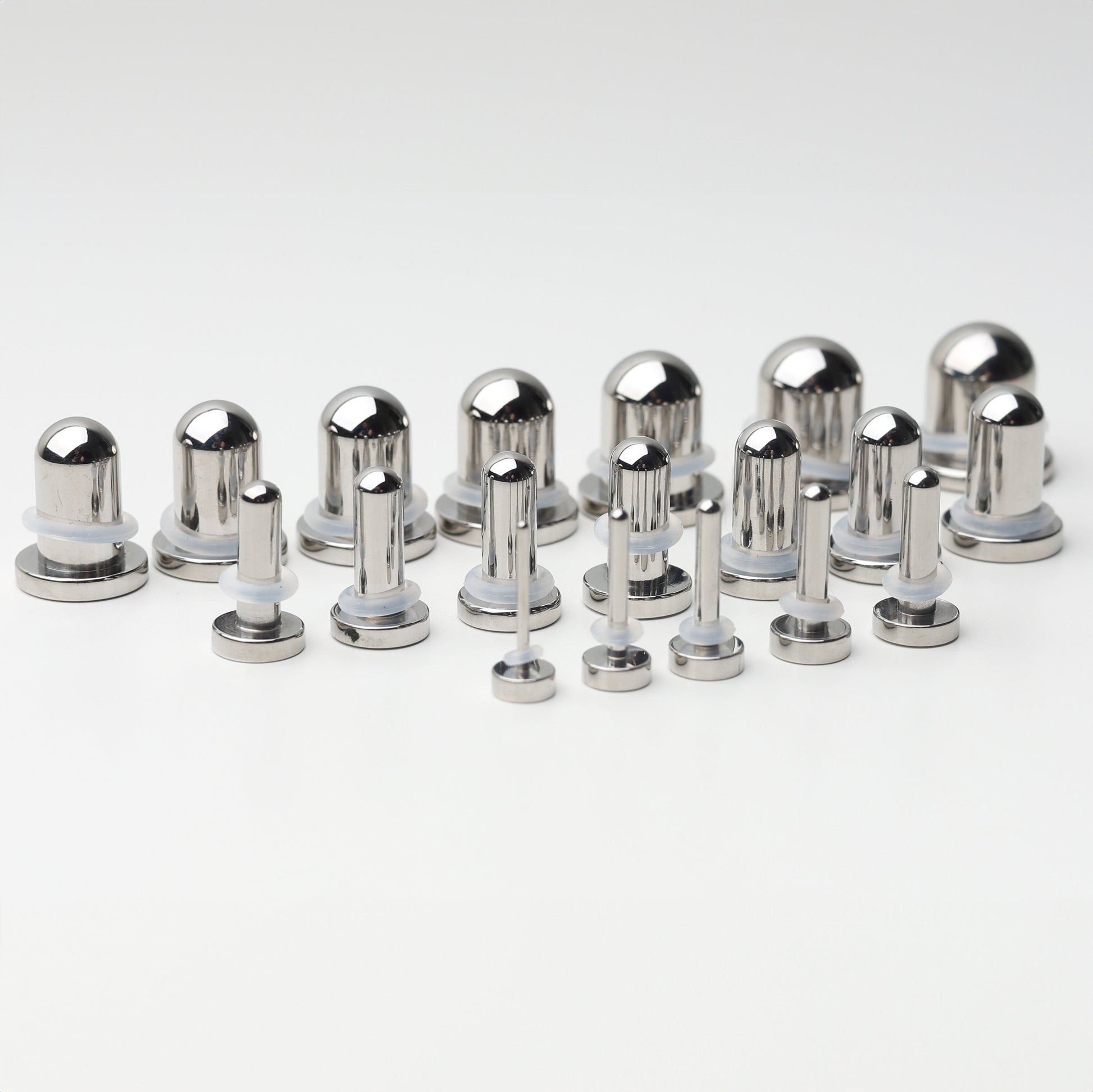 A complete dead stretching kit with polished stainless steel plugs and tunnels in multiple sizes, displayed on a white background.