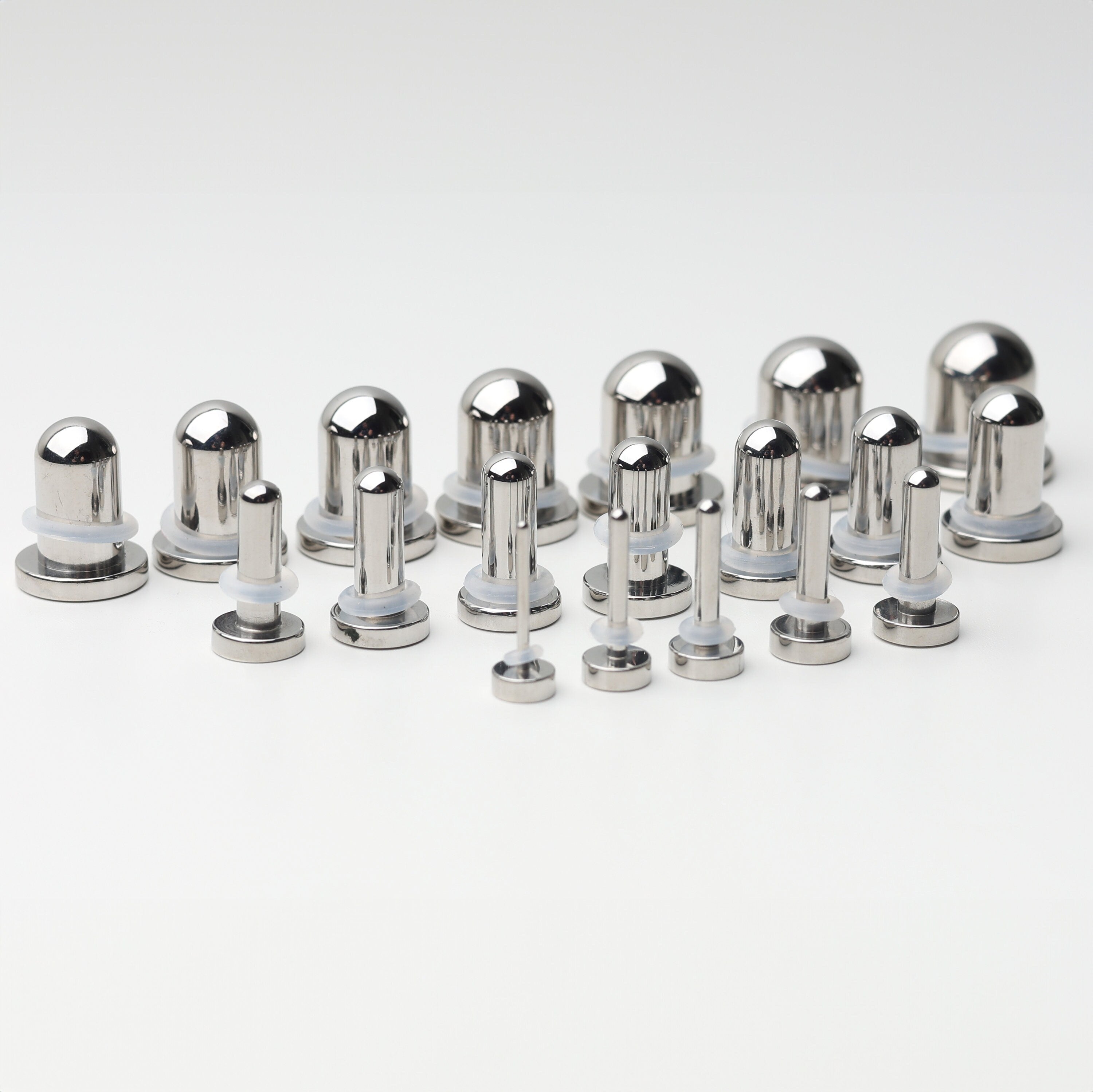 A complete dead stretching kit with polished stainless steel plugs and tunnels in multiple sizes, displayed on a white background.