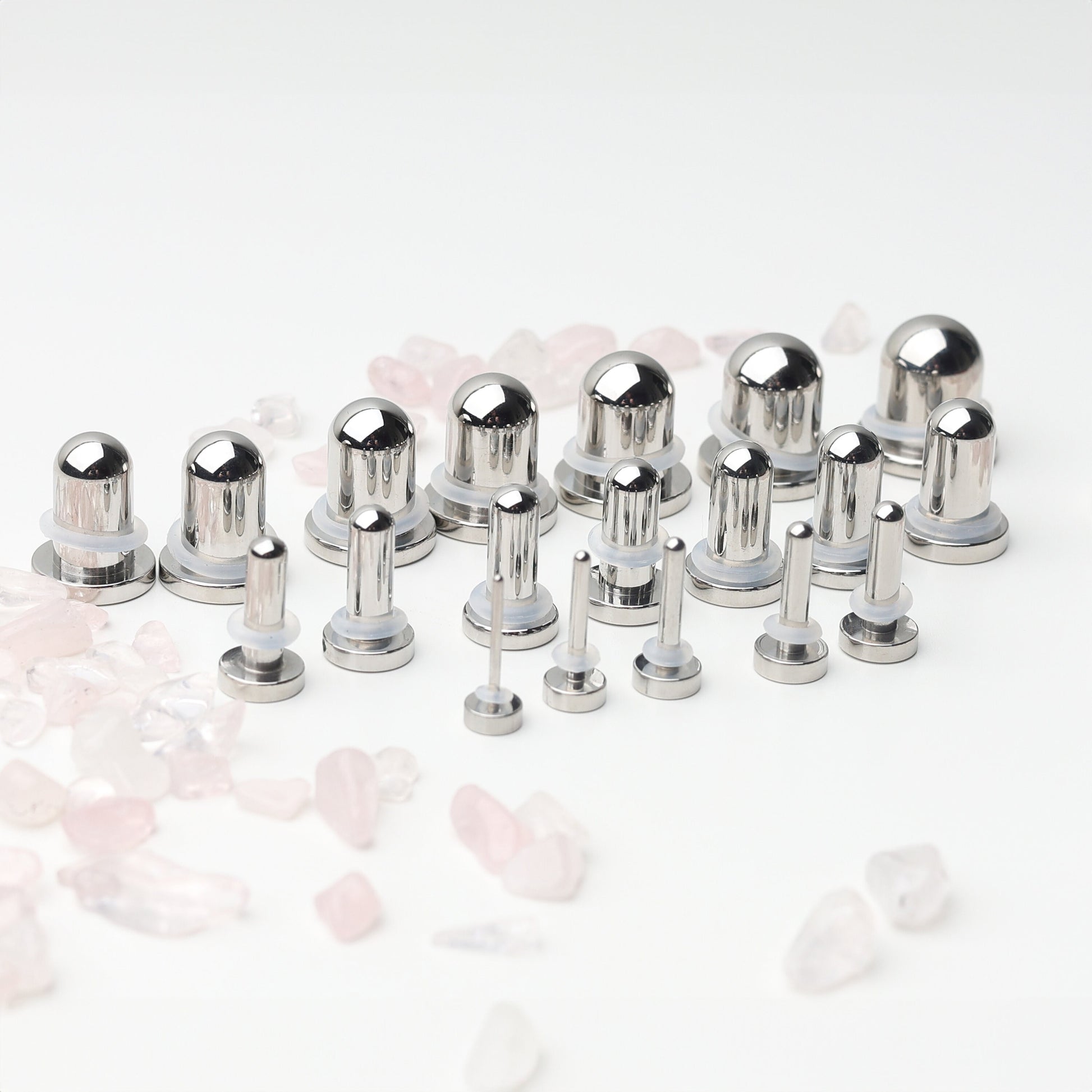 A complete dead stretching kit with polished stainless steel plugs and tunnels in multiple sizes, displayed on a white background