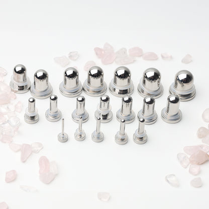 A complete dead stretching kit with polished stainless steel plugs and tunnels in multiple sizes, displayed on a white background with scattered rose quartz accents.