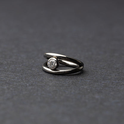 Titanium double-layered clicker with a single cubic zirconia centerpiece, displayed on a dark background.