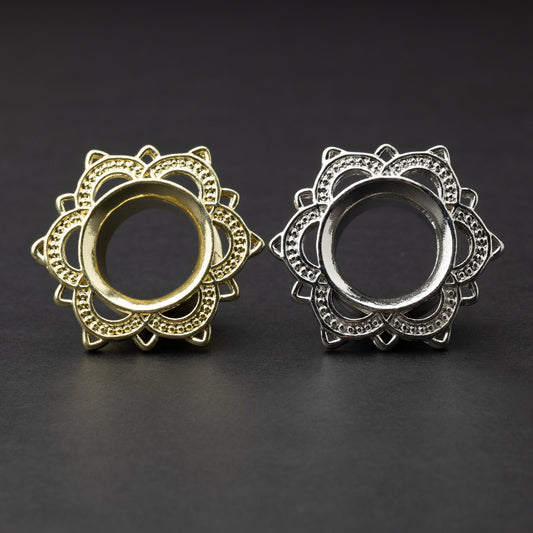 Gold and silver flower-shaped tunnels with intricate detailing, displayed on a dark background.