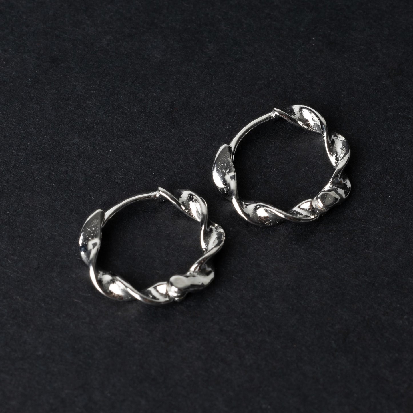 Gold-toned twisted rope design clickers made from 925 sterling silver, displayed on a black background.
