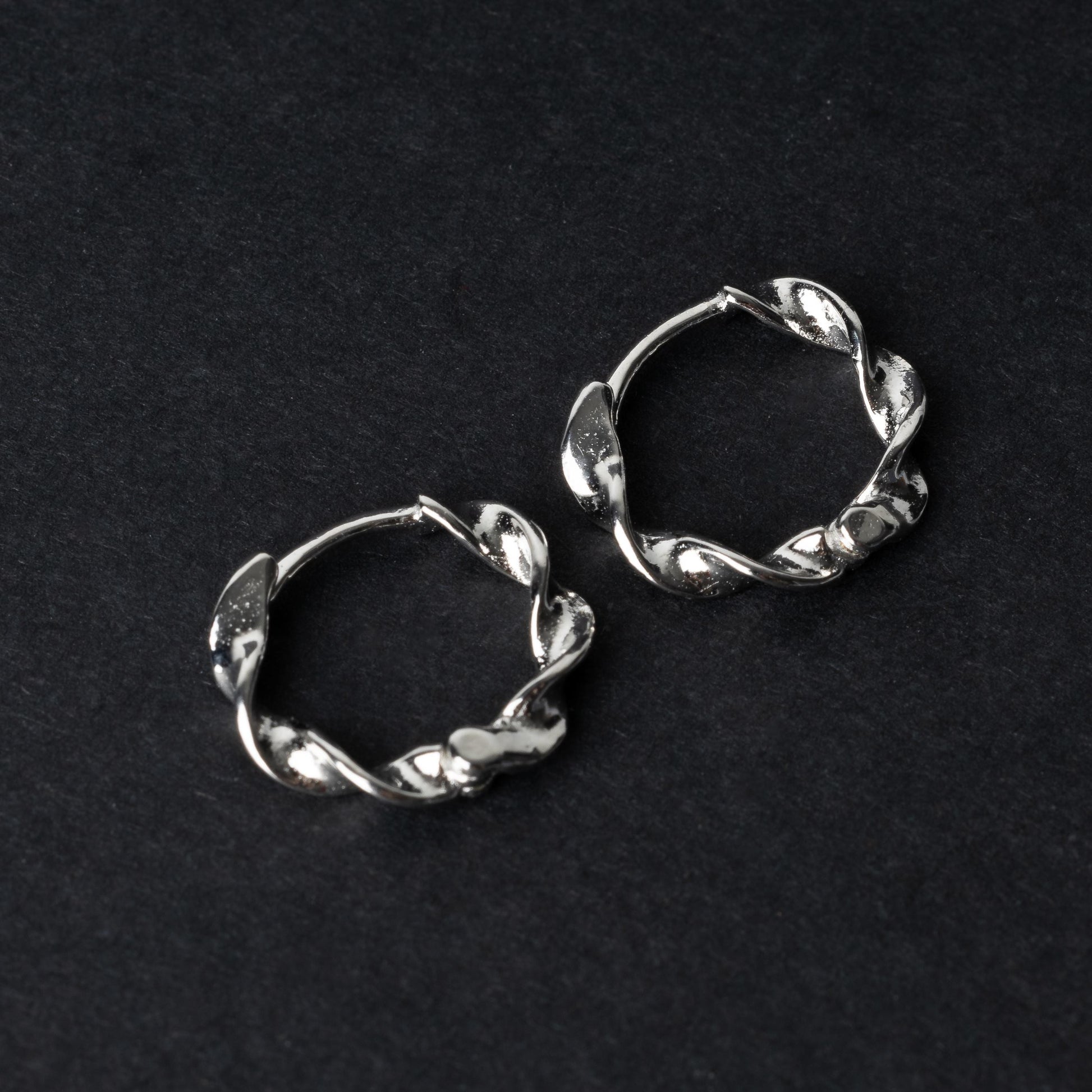 Gold-toned twisted rope design clickers made from 925 sterling silver, displayed on a black background.