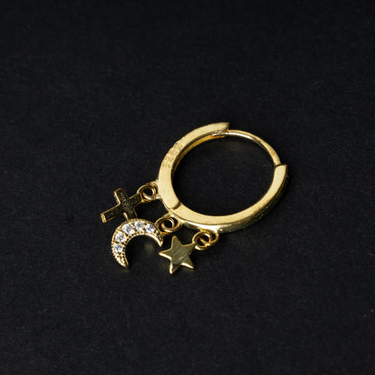 Gold clicker ring adorned with a moon charm encrusted with crystals, a star, and a cross, displayed on a dark background.