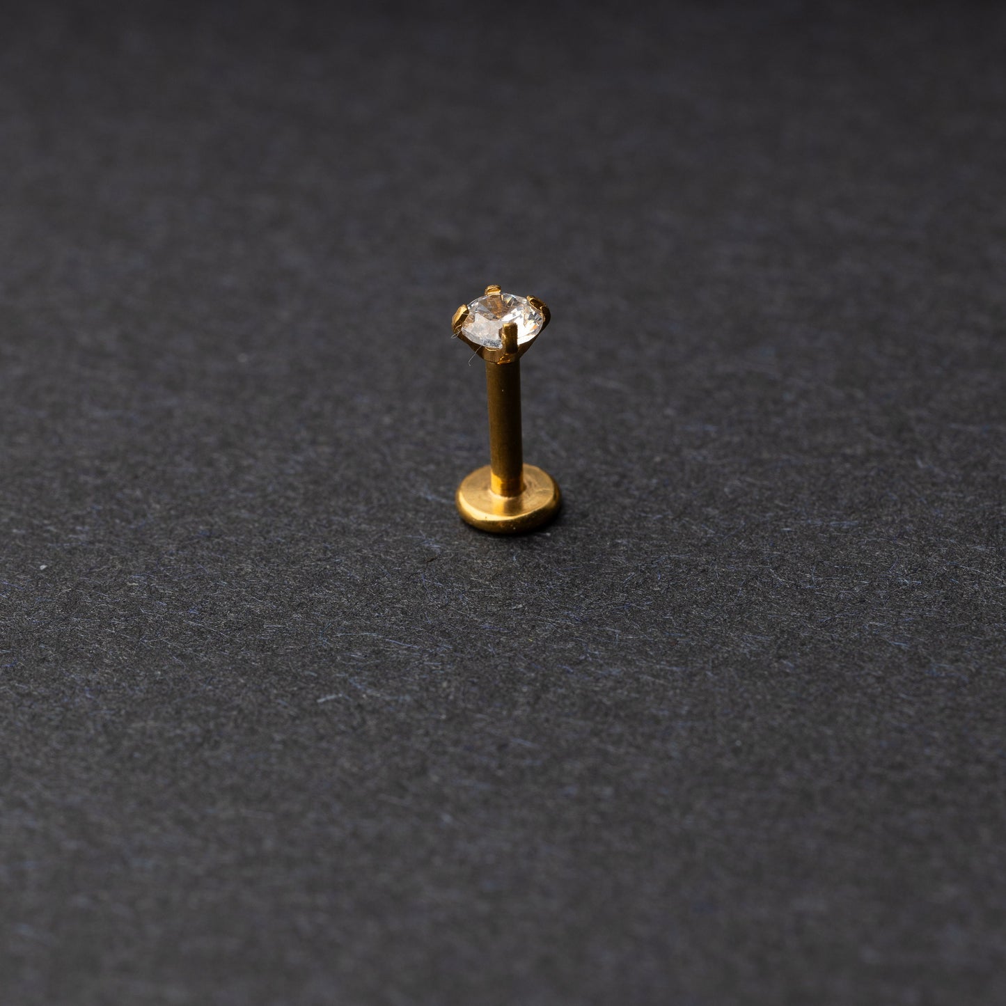 Gold Labret bar on a dark background