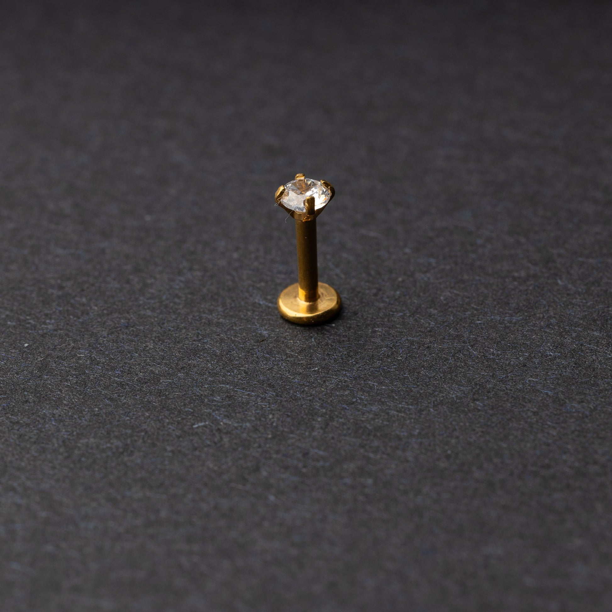 Gold Labret bar on a dark background