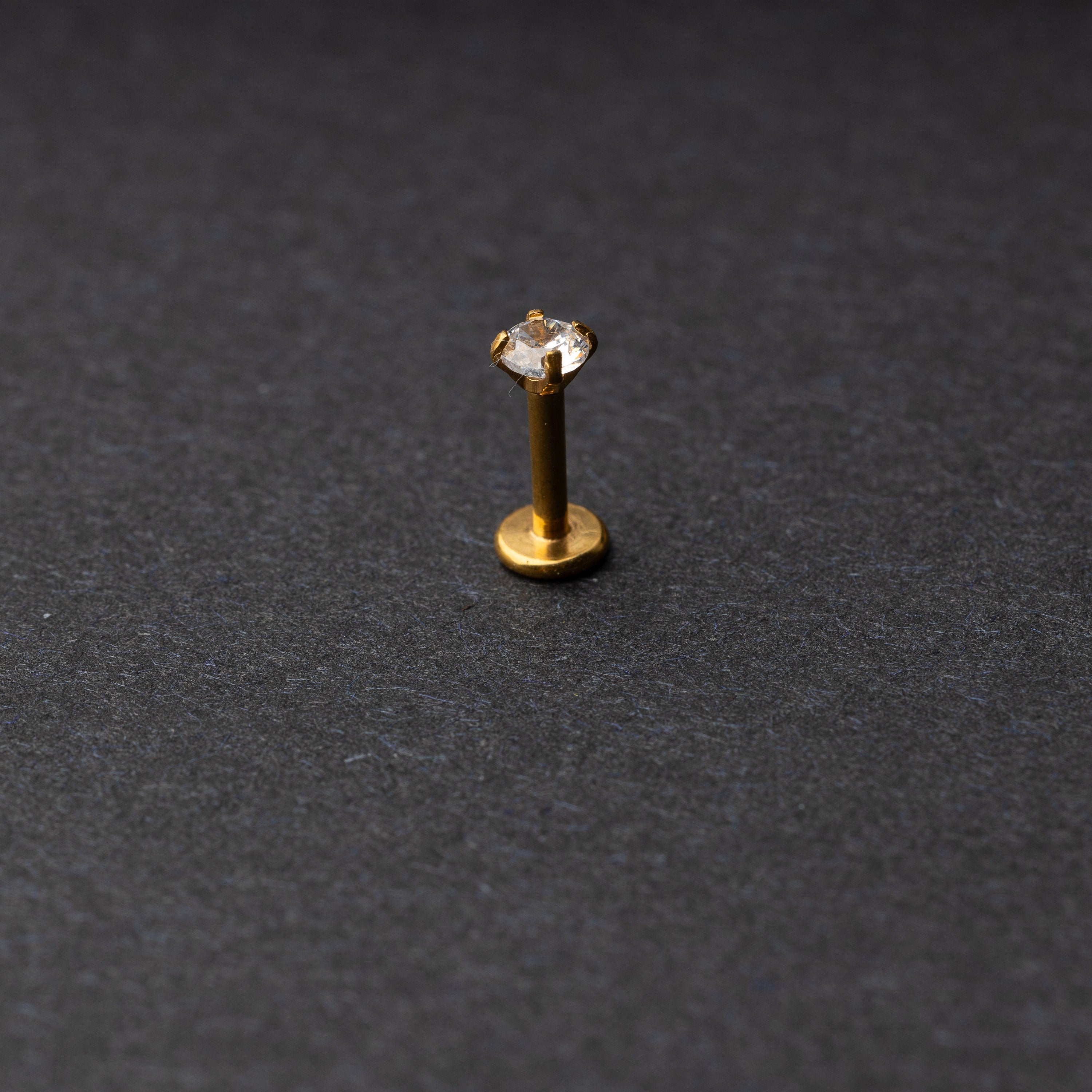 Gold Labret bar on a dark background