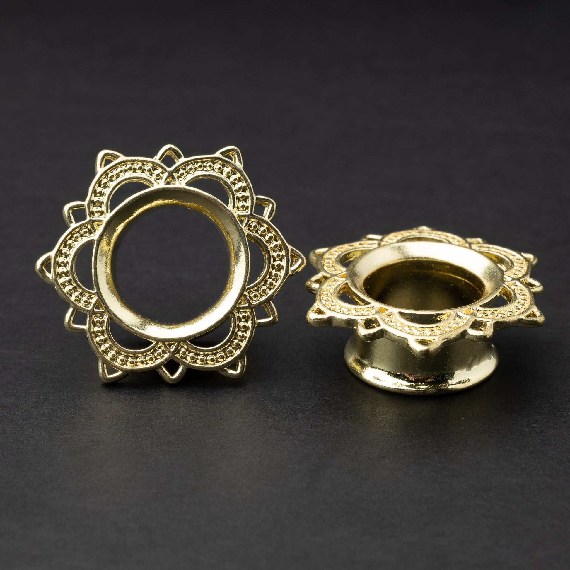 Gold flower-shaped tunnels with intricate detailing, displayed on a dark background.