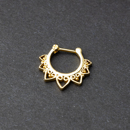 Gold septum clickers with intricate geometric and swirl detailing.