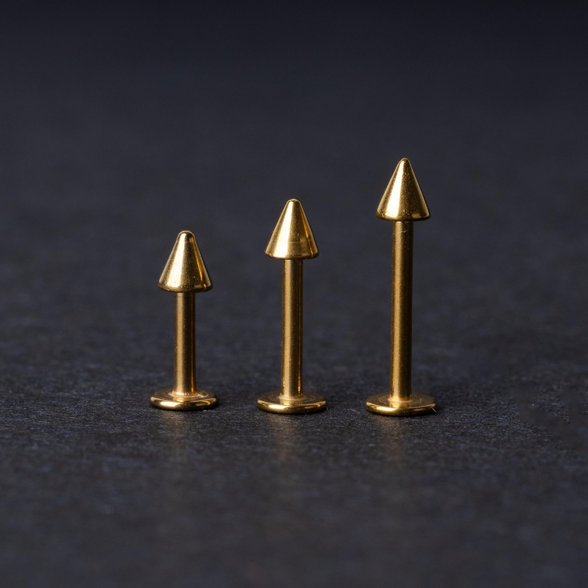 Three sizes of spiked bar back displayed on a dark background.