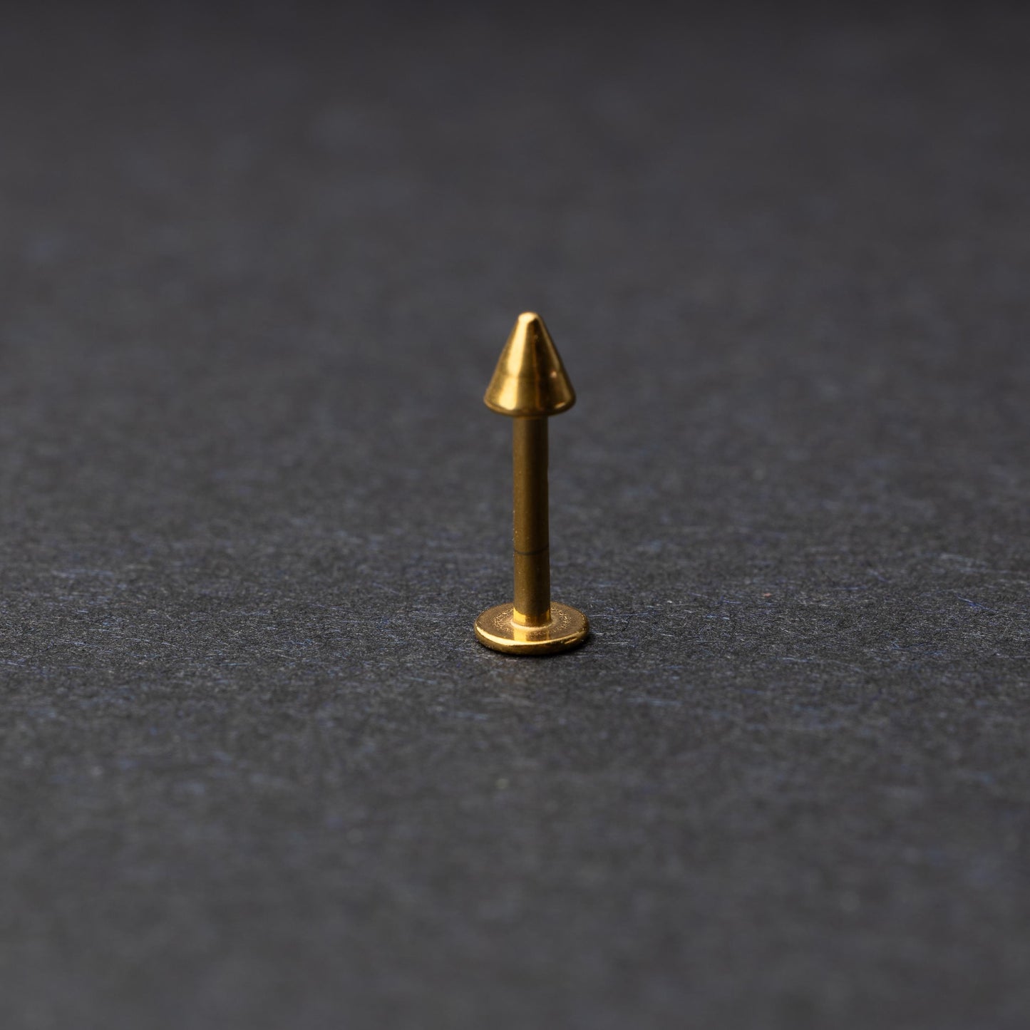 A single spiked flat back bar on a dark background. 