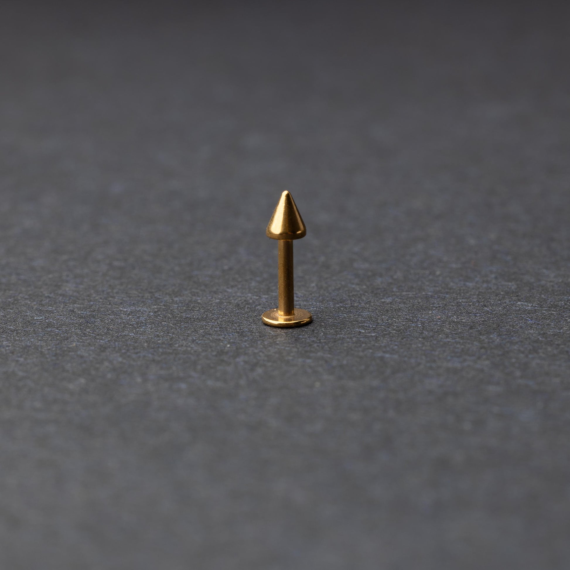A single spiked flat back bar on a dark background. 