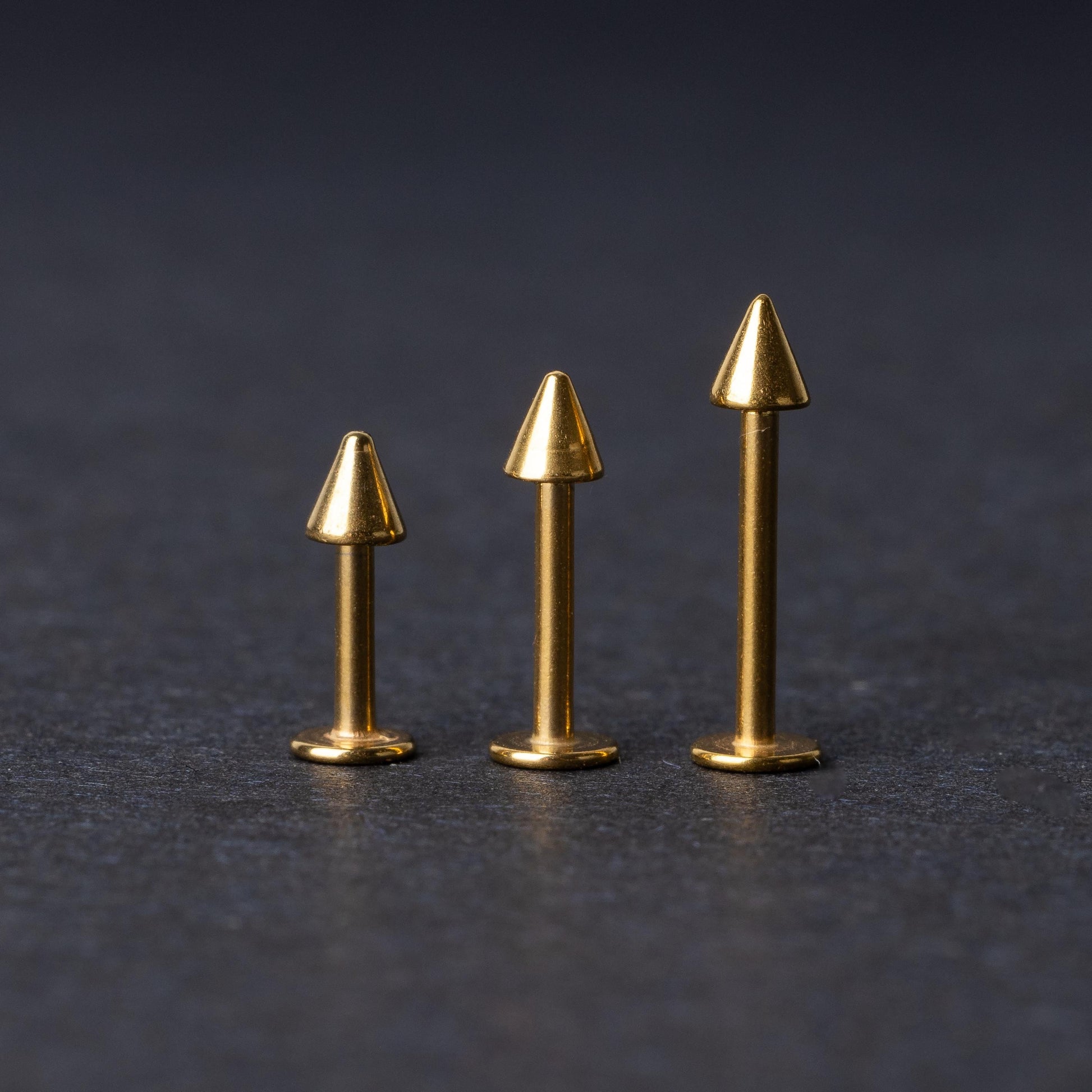 Three sizes of spiked bar back displayed on a dark background.