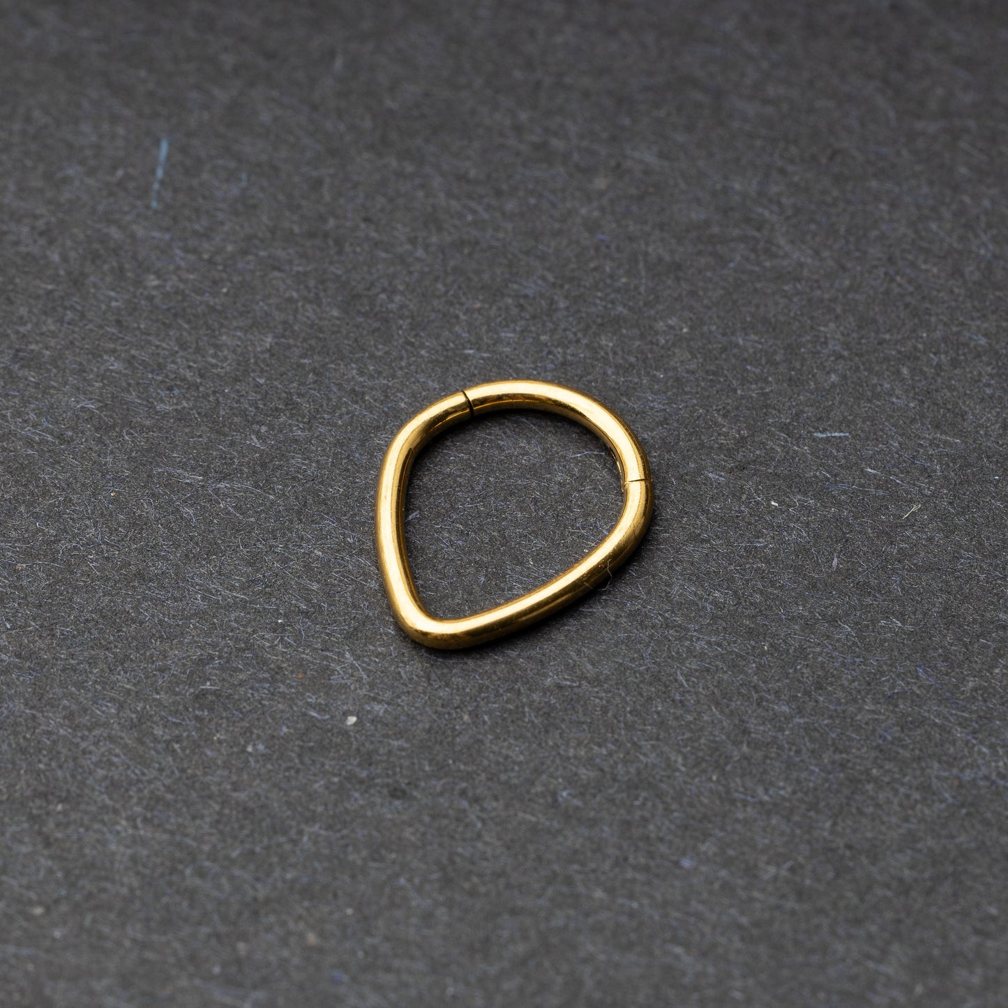 Gold Teardrop Clicker displayed on a dark background