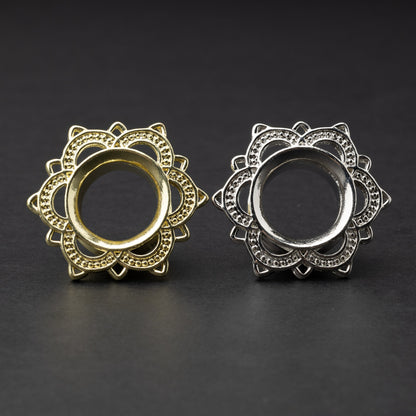 Gold and silver flower-shaped tunnels with intricate detailing, displayed on a dark background.