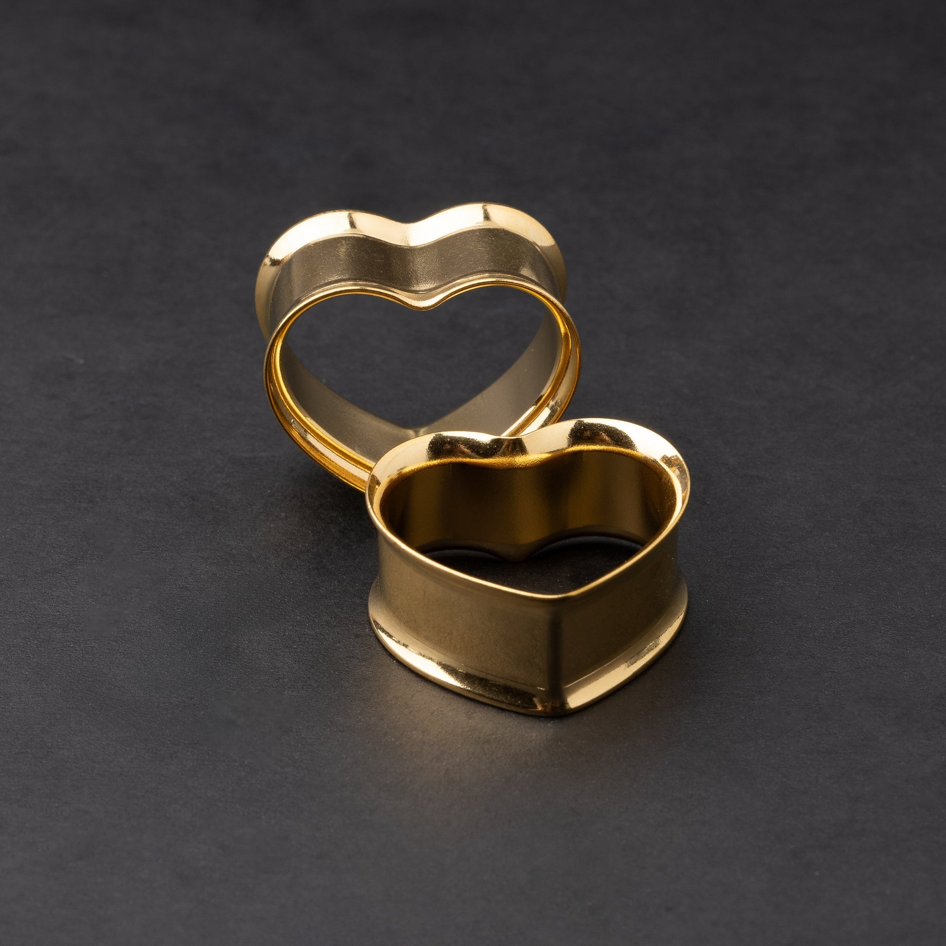 Heart-shaped tunnels in gold, displayed on a dark background.