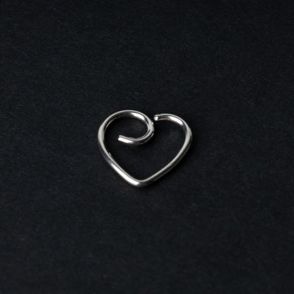 Silver heart shaped daith on a dark background