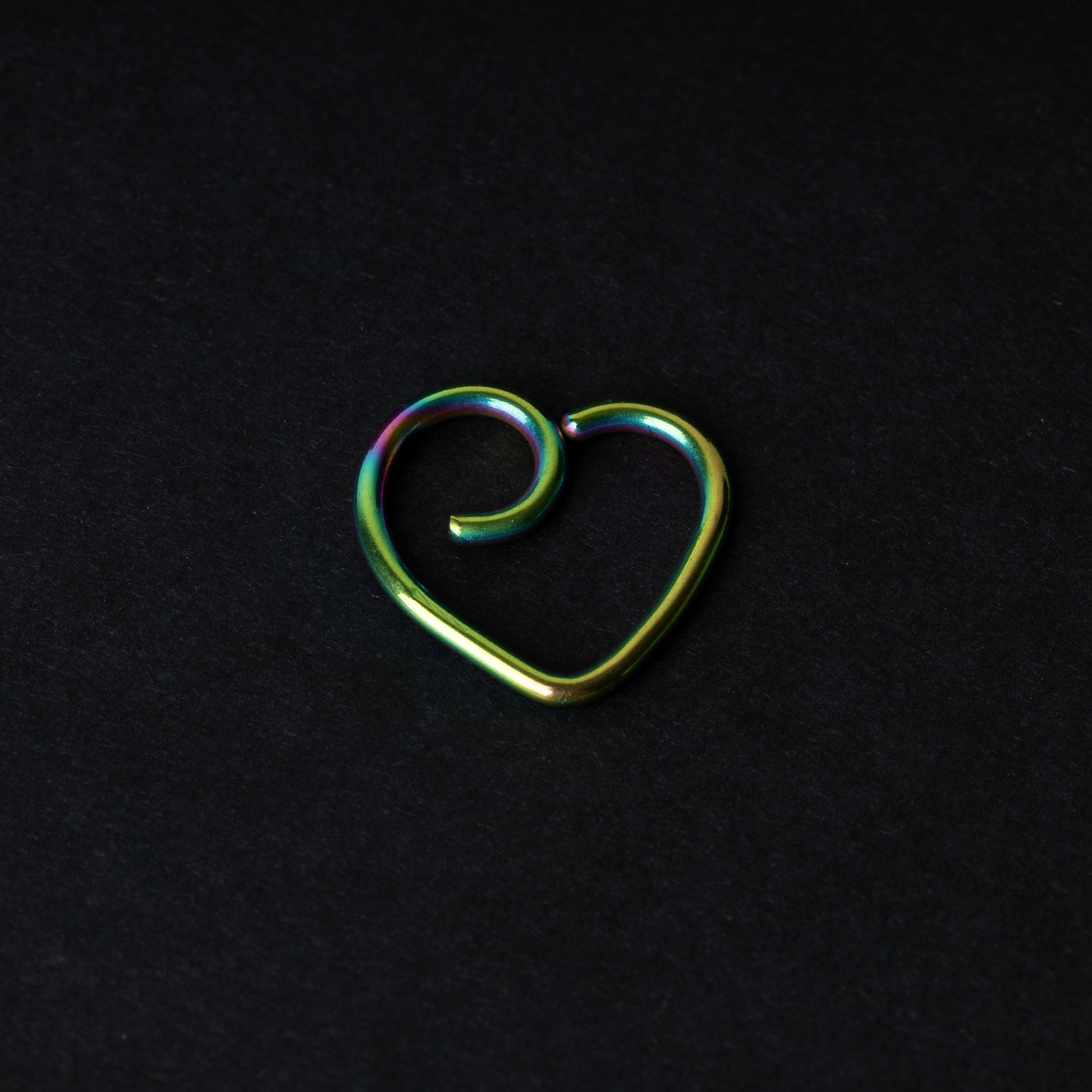 Rainbow heart shaped daith on a dark background