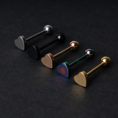 Heart-shaped tongue bars in black, silver, rose gold, rainbow, and gold finishes, displayed on a dark background.