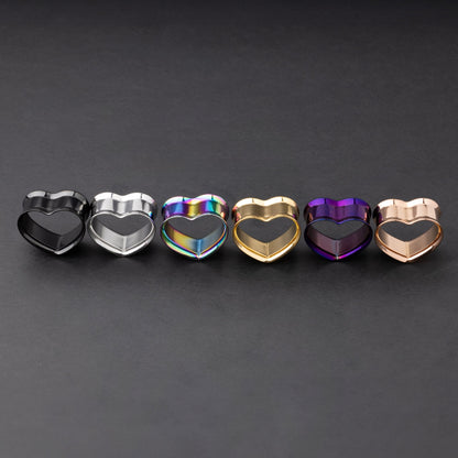 Heart-shaped tunnels in black, silver, rainbow, gold, purple, and rose gold finishes, displayed on a dark background.