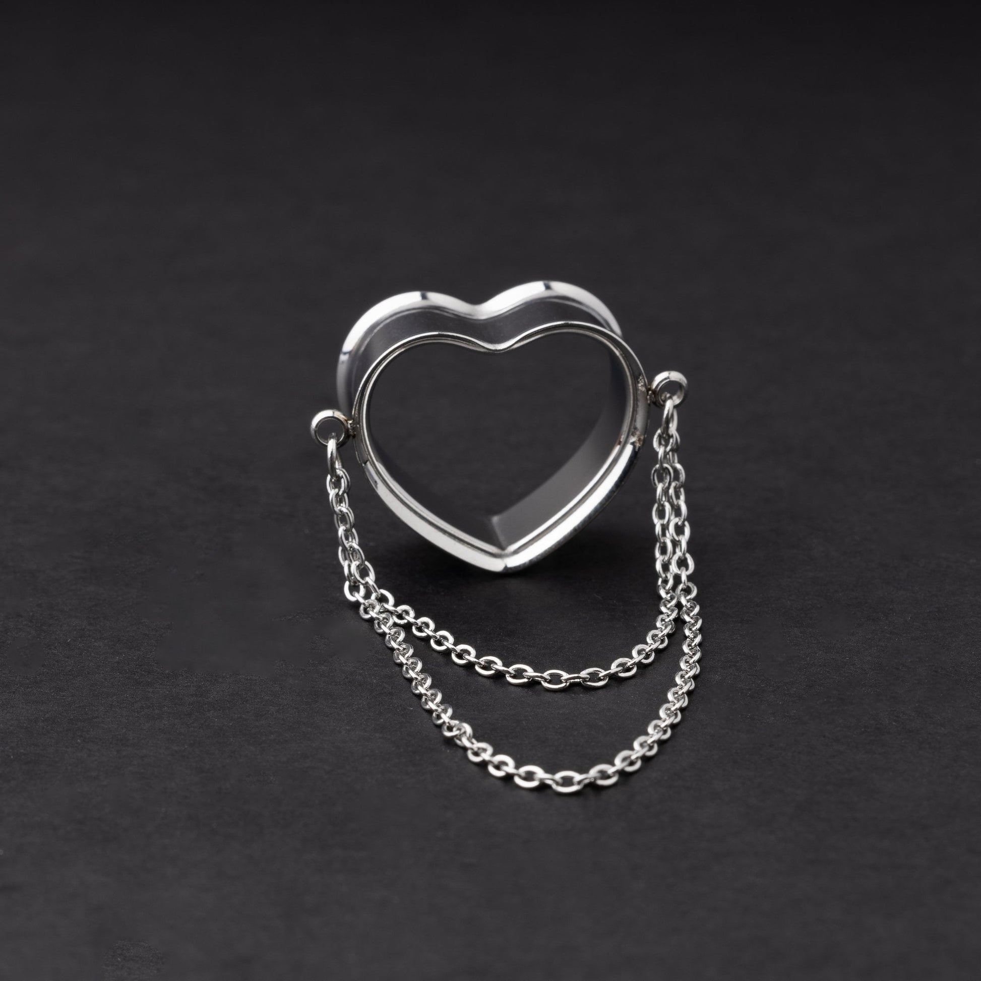 Heart-shaped tunnel with draped chains in silver, displayed on a dark background.