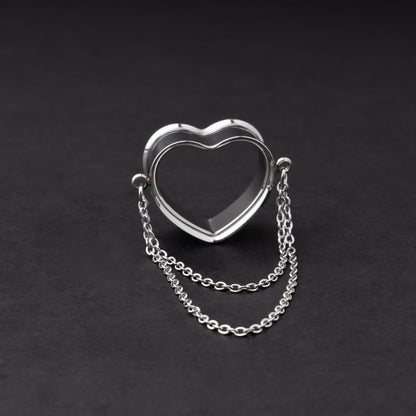 Heart-shaped tunnel with draped chains in silver, displayed on a dark background.