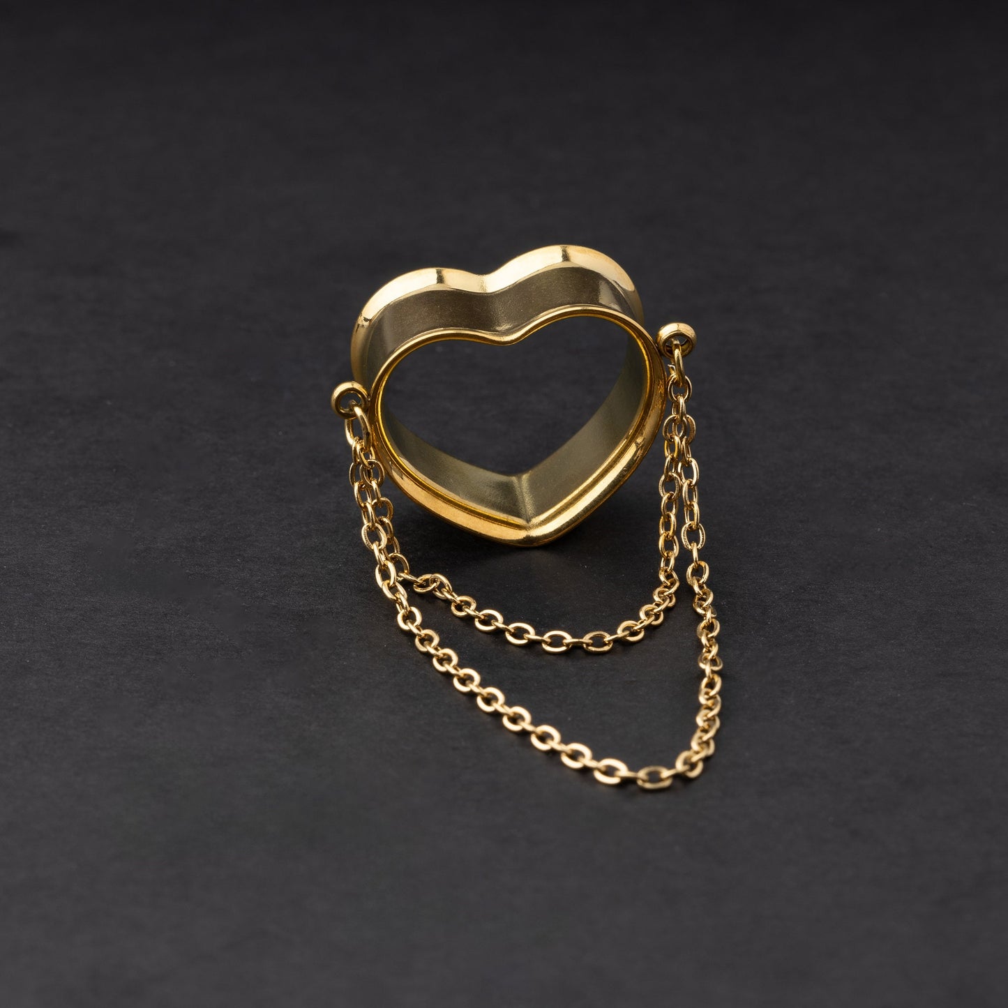 Heart-shaped tunnel with draped chains in gold, displayed on a dark background.
