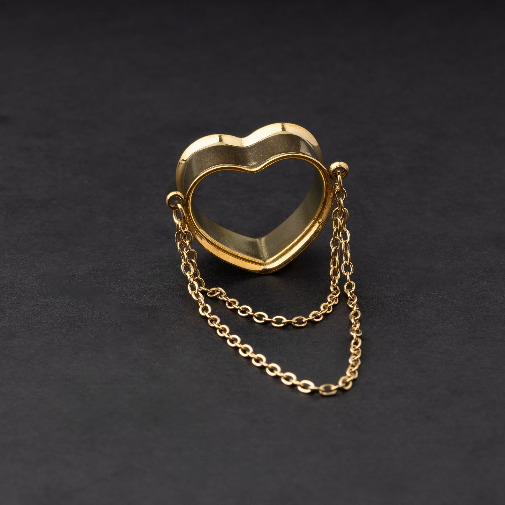 Heart-shaped tunnel with draped chains in gold, displayed on a dark background.