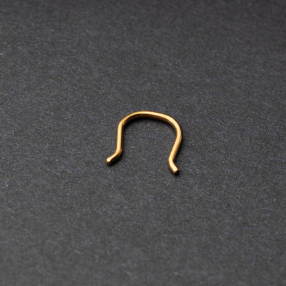 U-shaped septum retainer in rose gold displayed on a dark background