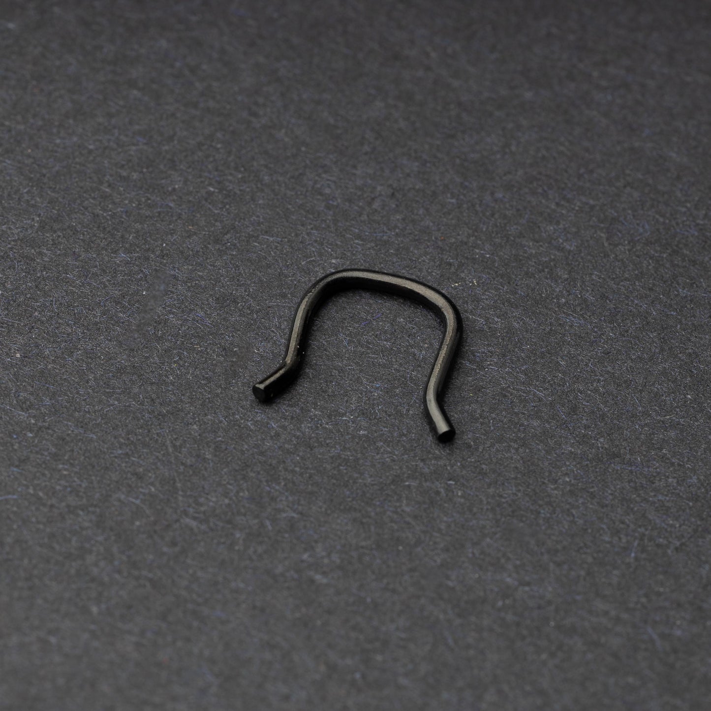 U-shaped septum retainer in black displayed on a dark background