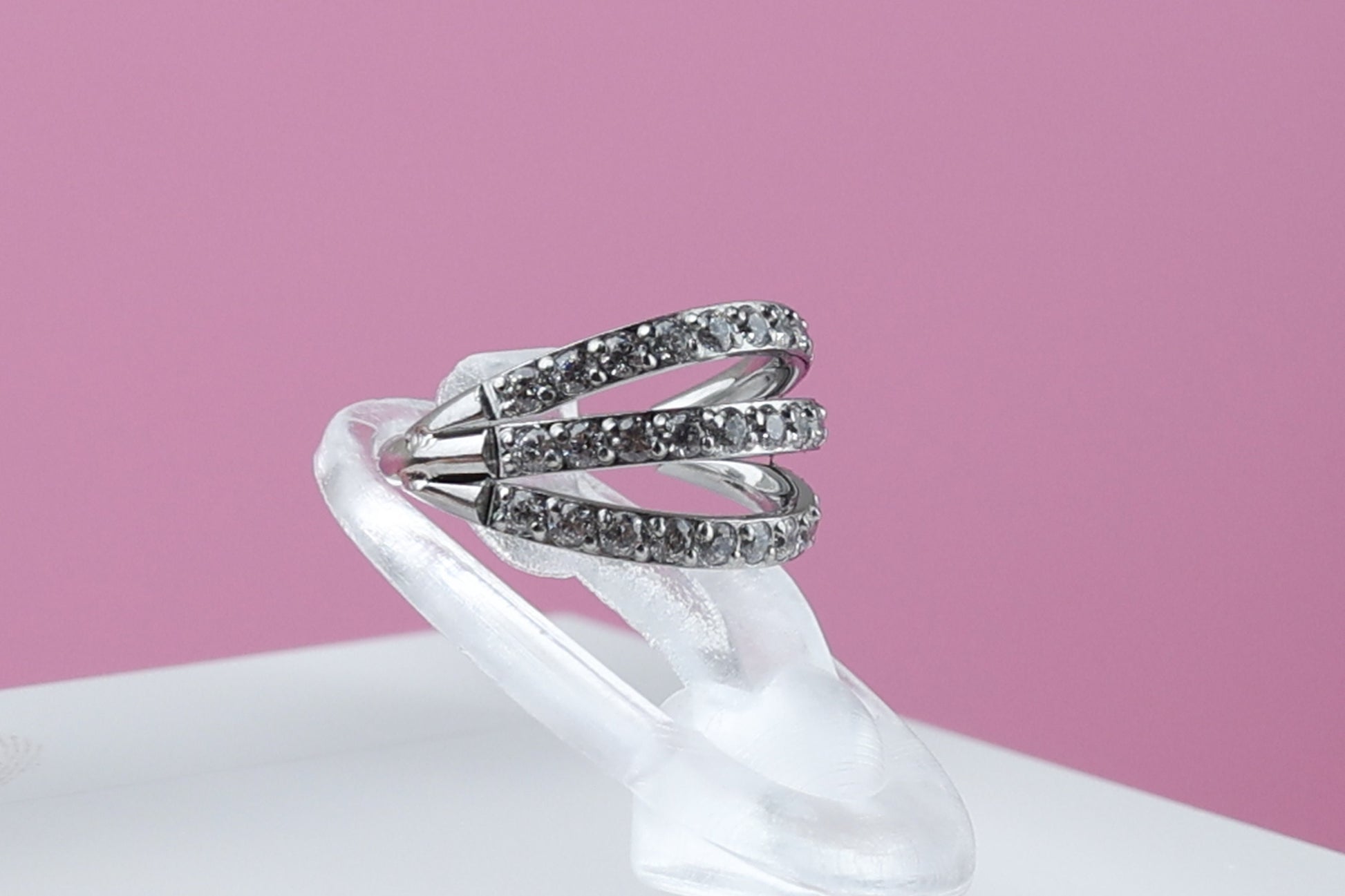 Triple-band clicker ring encrusted with cubic zirconia stones, displayed on a dark background, showcasing its elegant and sparkling design.