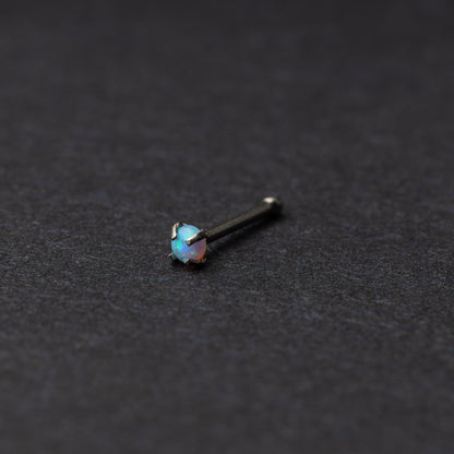 Light blue nose stud displayed on a dark background