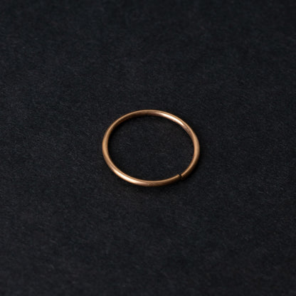 A single thin rose gold seamless hoop with a polished finish, displayed on a dark background.