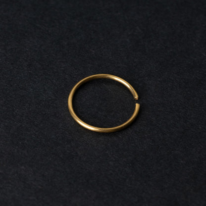 A single thin gold seamless hoop with a polished finish, displayed on a dark background.