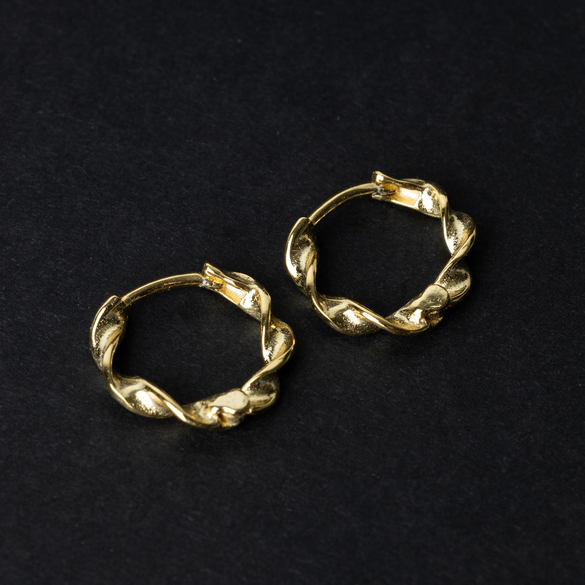 Gold-toned twisted rope design clickers made from 925 sterling silver, displayed on a black background.