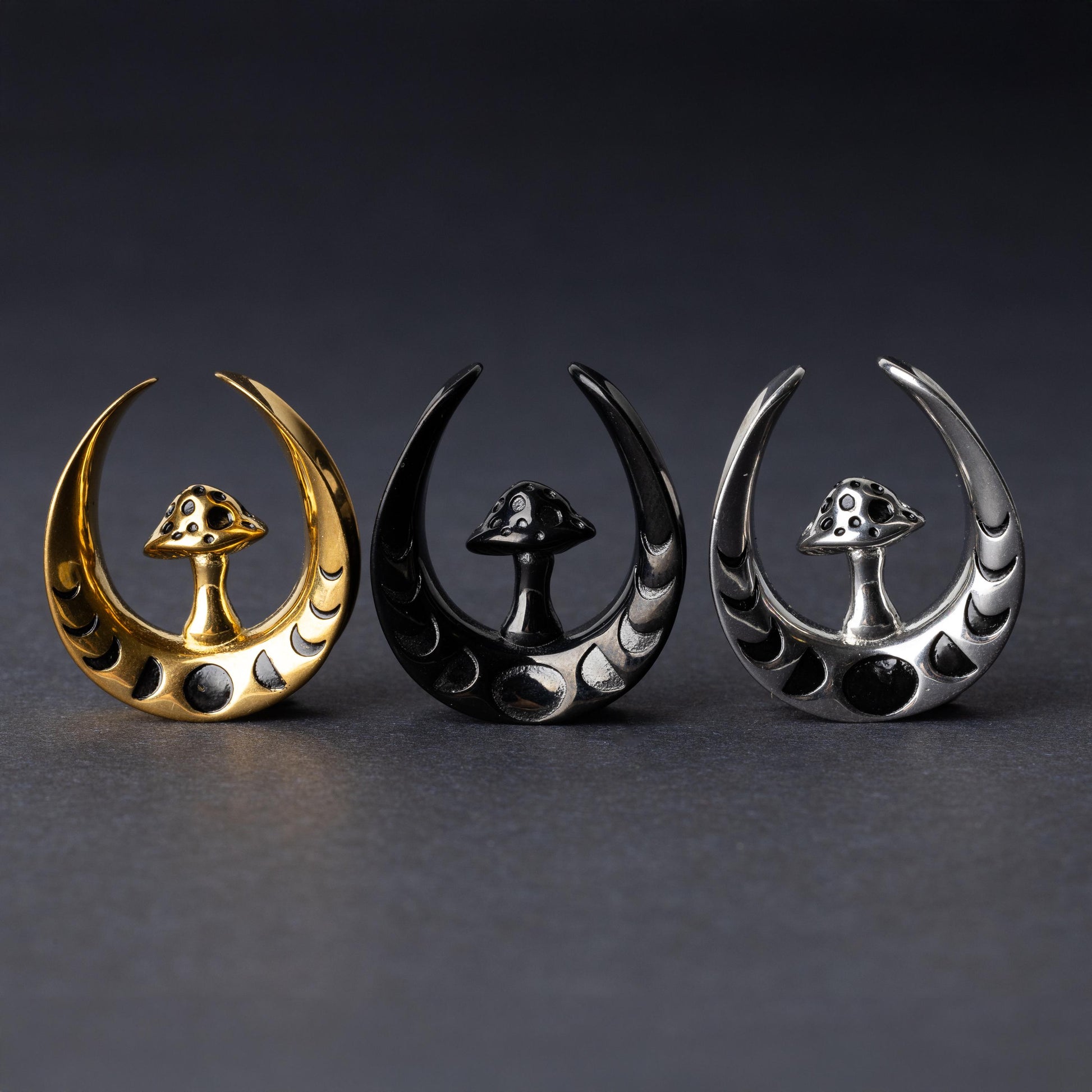 Crescent moon tunnels with mushroom detailing in gold, black, and silver finishes, displayed on a dark background.
