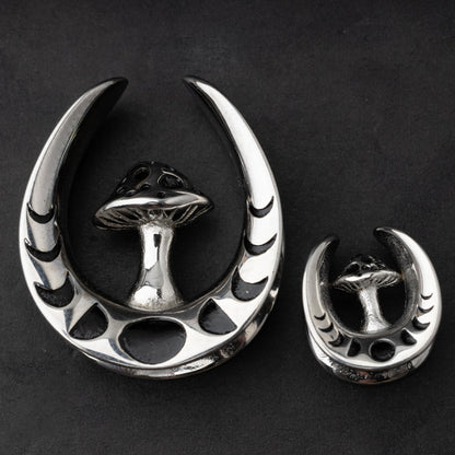 Pair of crescent moon tunnels with mushroom detailing in silver, displayed on a dark background.
