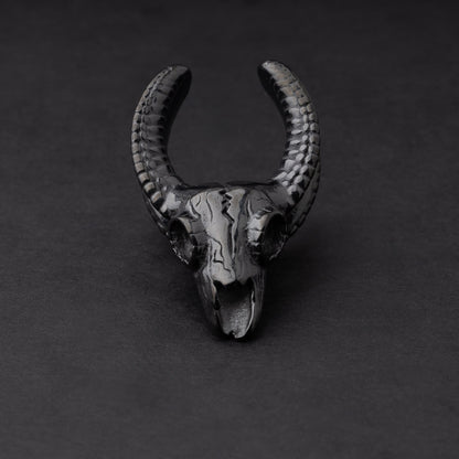 Ram skull saddle tunnel in black, showcasing intricate skull details and bold design on a dark background.