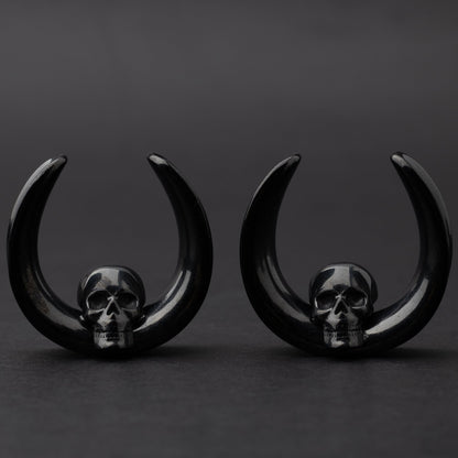 Pair of Skull design saddle tunnels in black, displayed on a dark background.