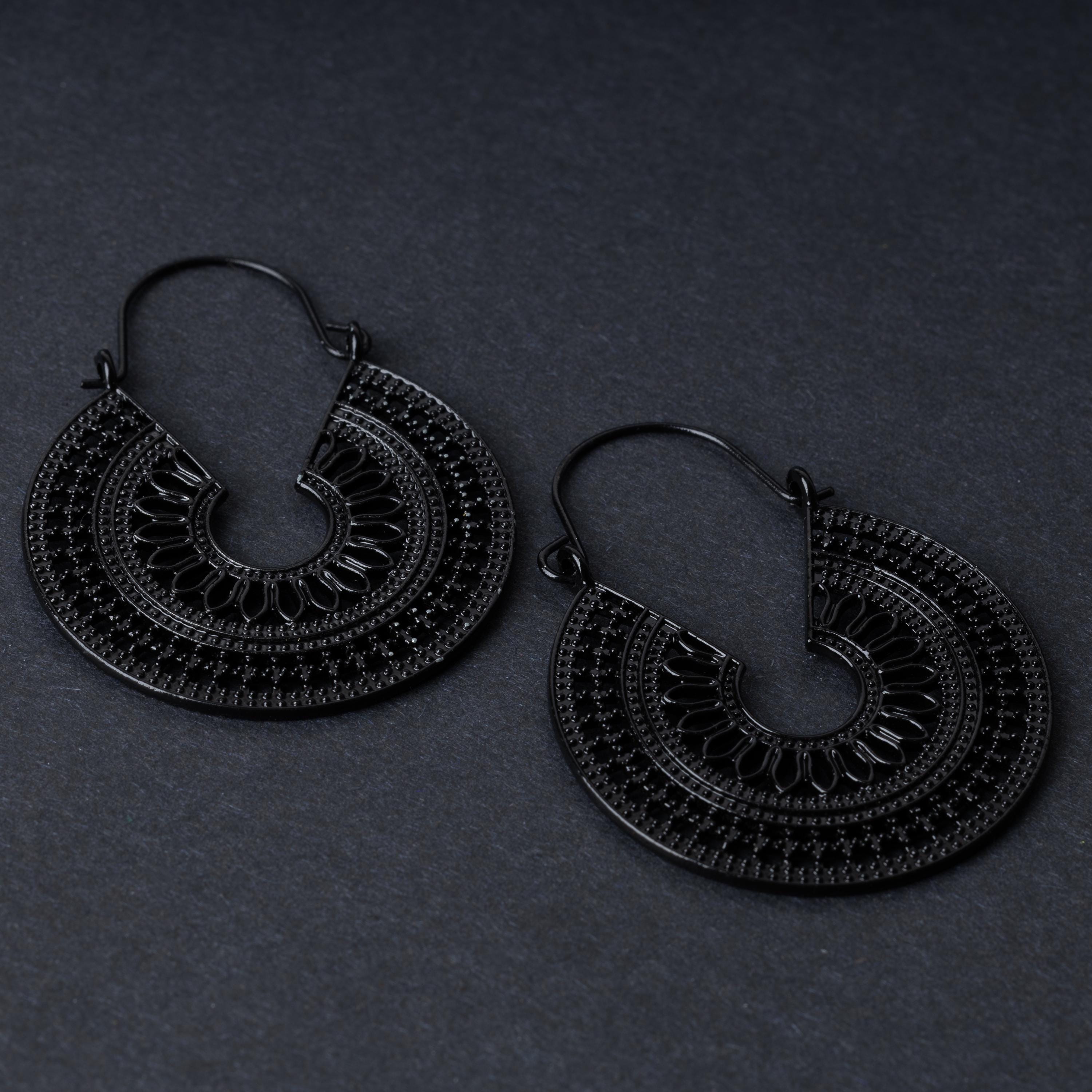 Pair of black hoop earrings with intricate cutout details and textured patterns, displayed on a dark background.