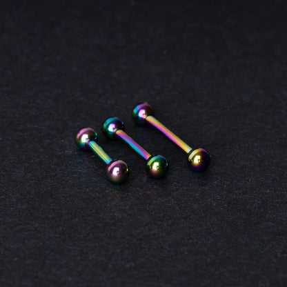 Rainbow stainless steel barbells with an anodized finish on a dark background.