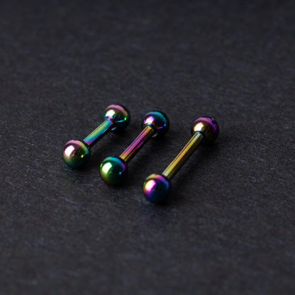 Rainbow stainless steel barbells with an anodized finish on a dark background.