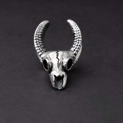 Ram skull saddle tunnel in silver, showcasing intricate skull details and bold design on a dark background.