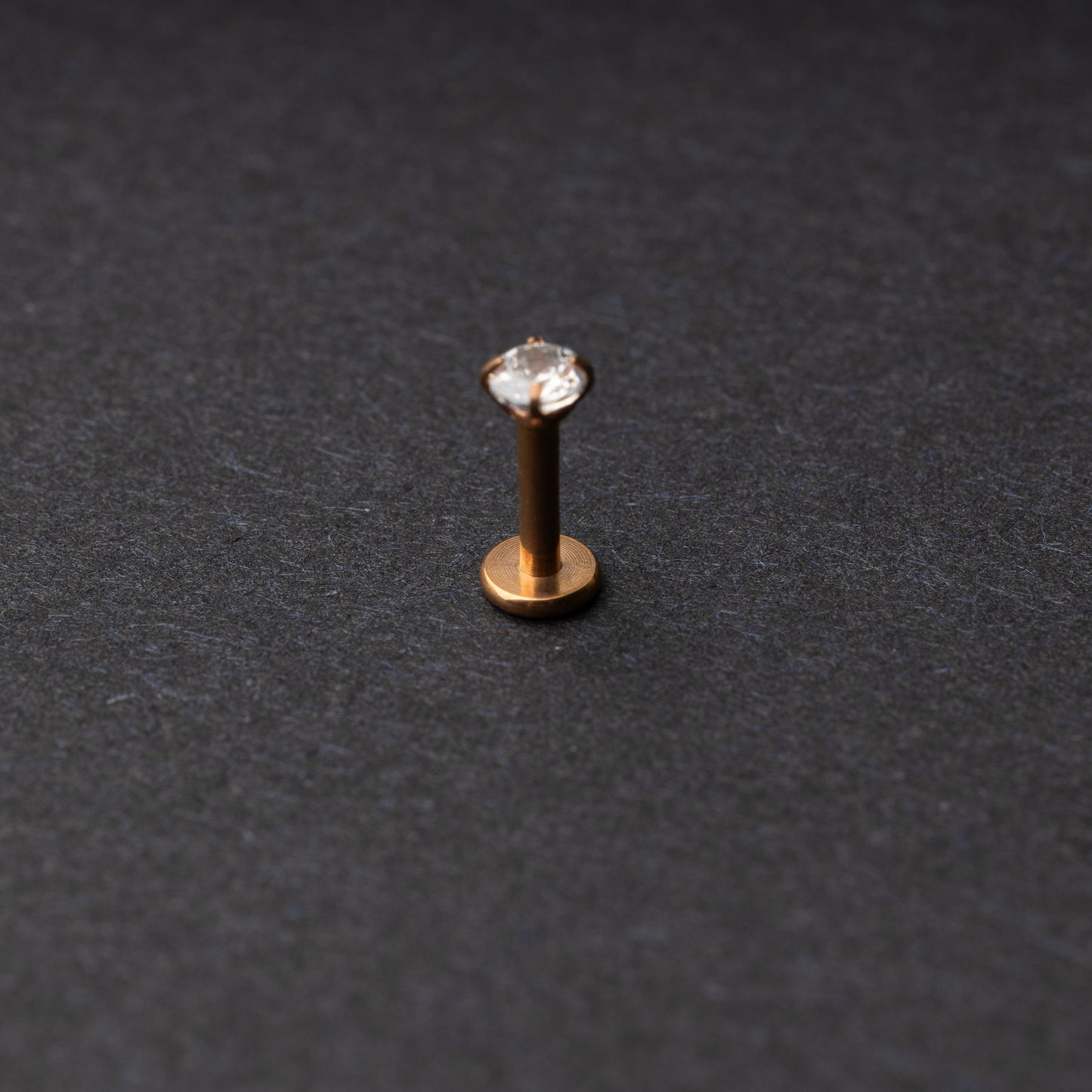 Rose Gold Labret bar on a dark background