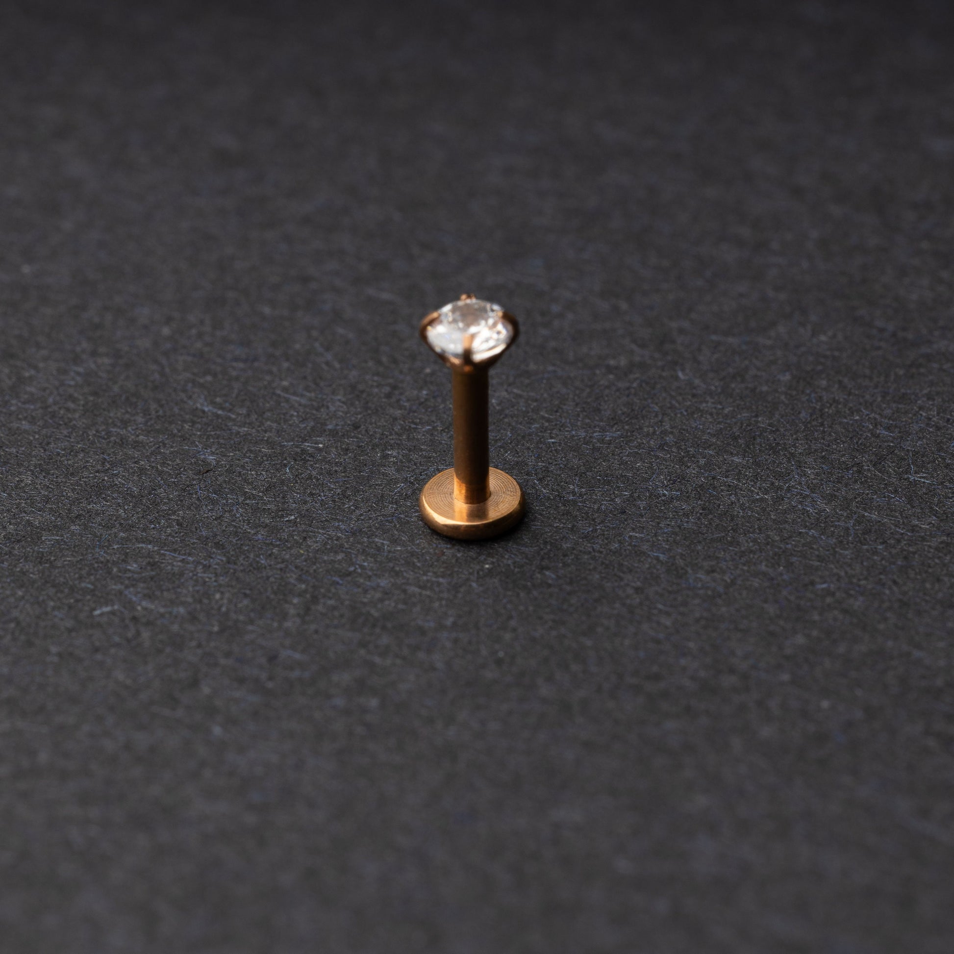 Rose Gold Labret bar on a dark background