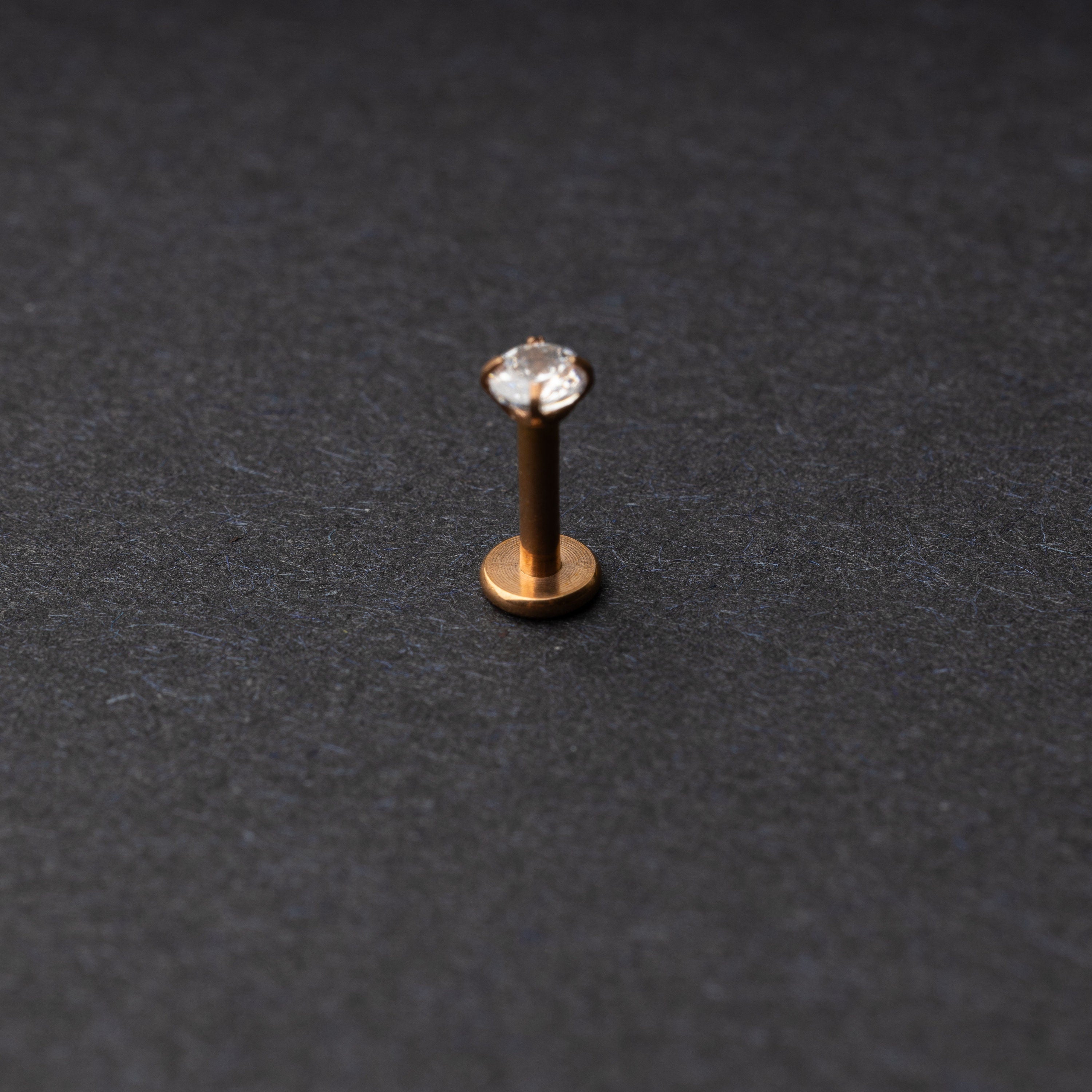 Rose Gold Labret bar on a dark background