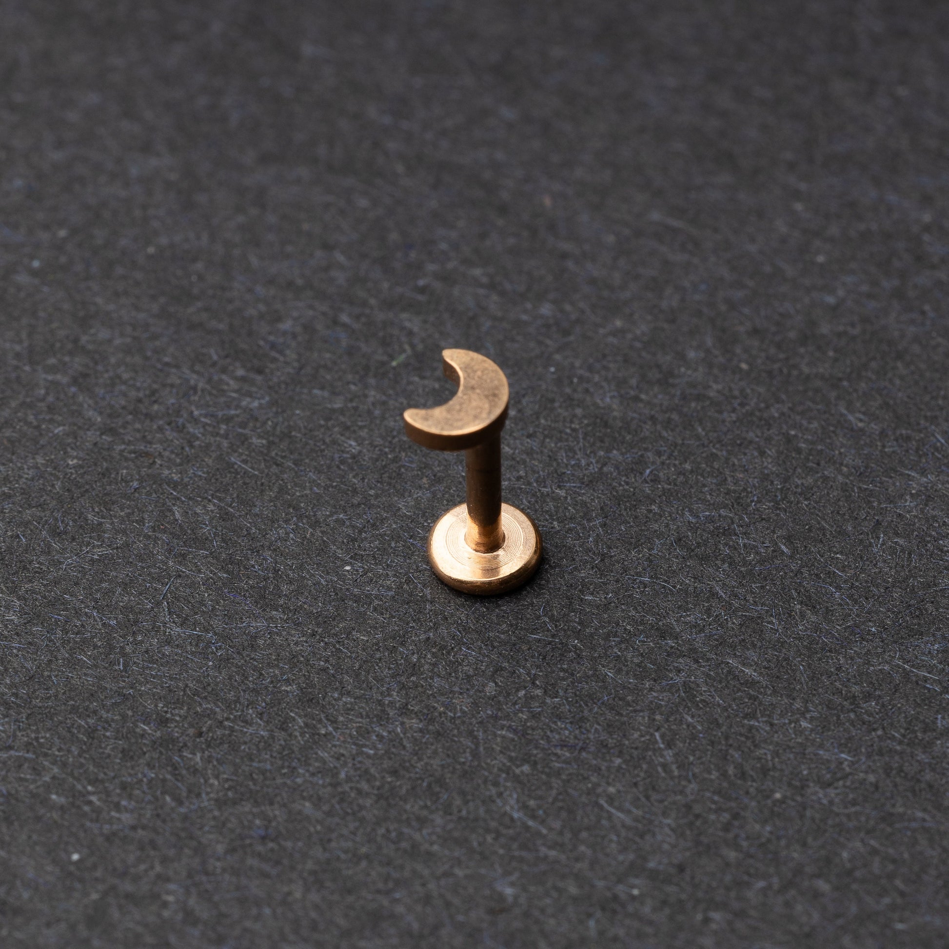Moon flat back bar in rose gold displayed on a dark background
