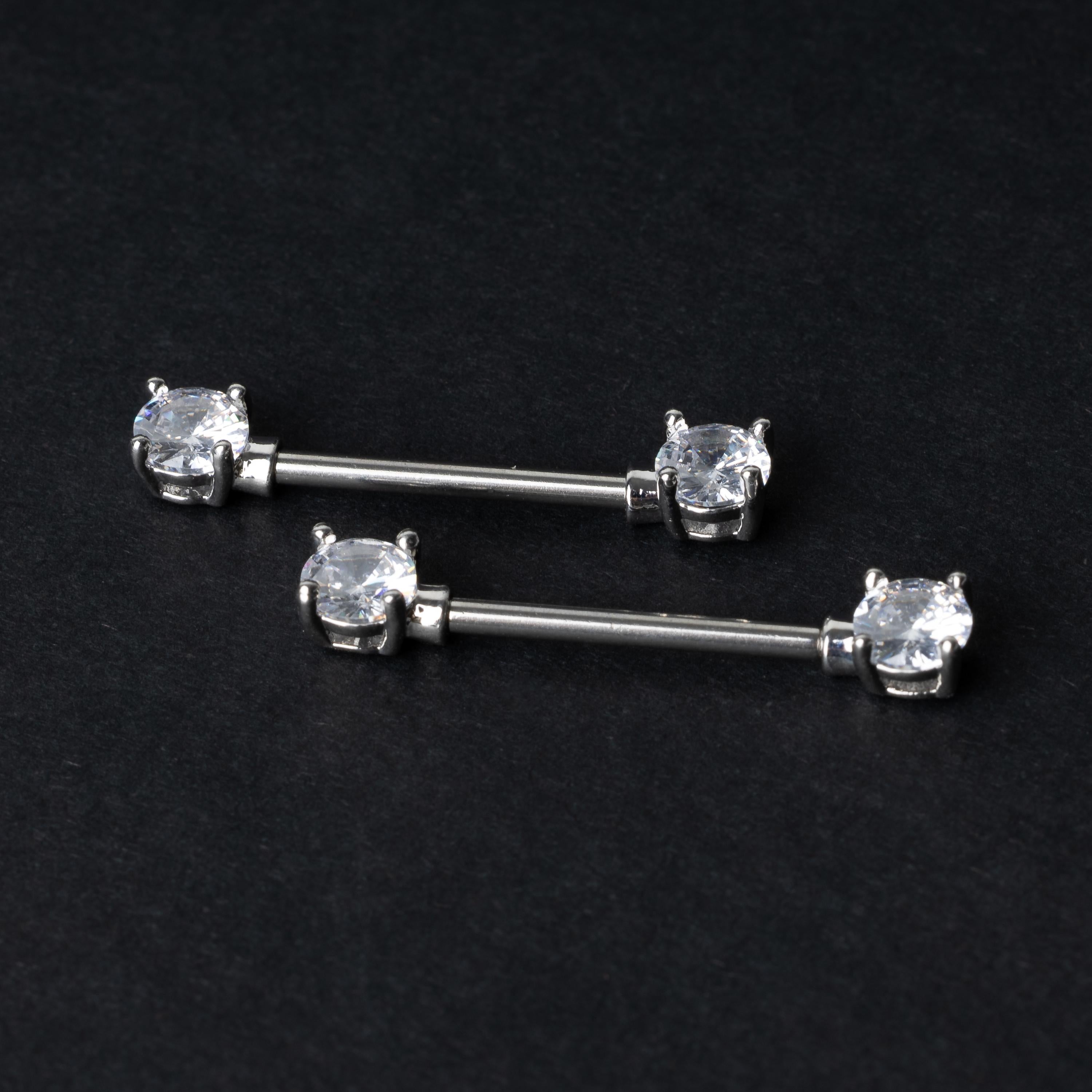 Crystal-studded barbells in silver displayed on a dark background.