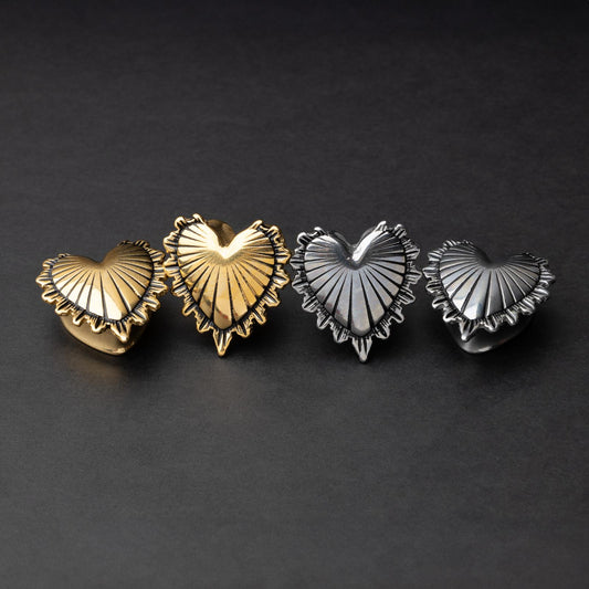 Sacred Heart plugs in gold and silver finishes, showcasing intricate 3D heart designs with a radiant pattern, displayed on a matte dark background.